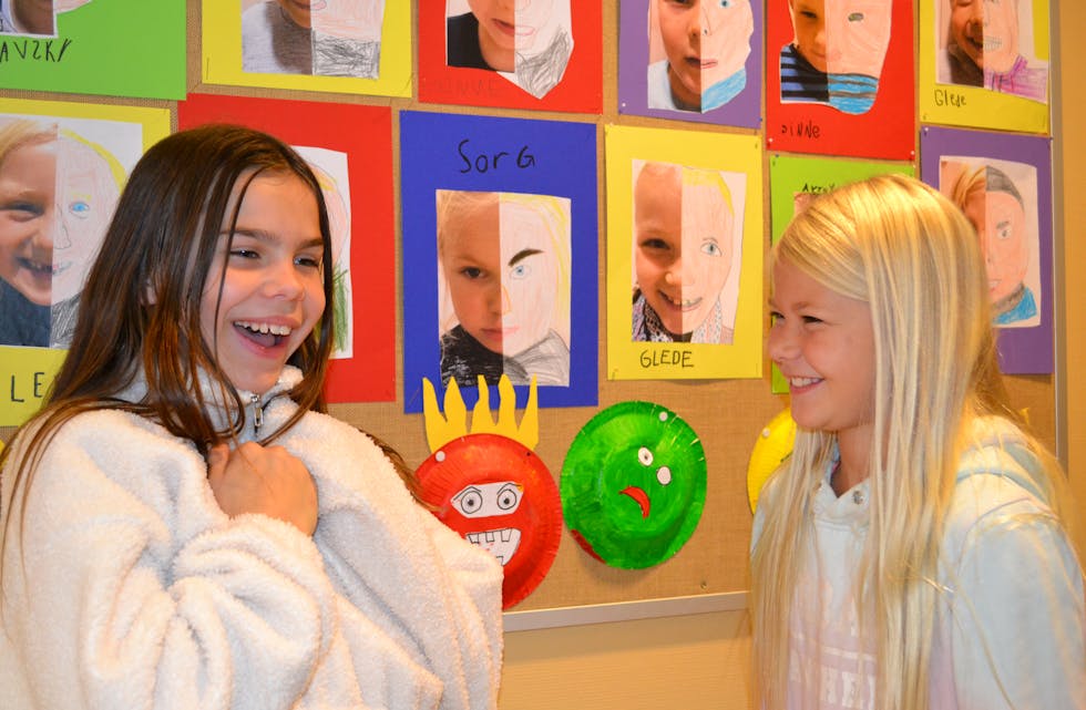 KUNSTUTSTILLING: Alle elevar ved Folkestad skule har bidratt i kunstutstillinga som illustrerer følelsar. Victoria Blichfeldt Dyrland og Celine Stokstad Stavenes viser her fram følelsen glede.