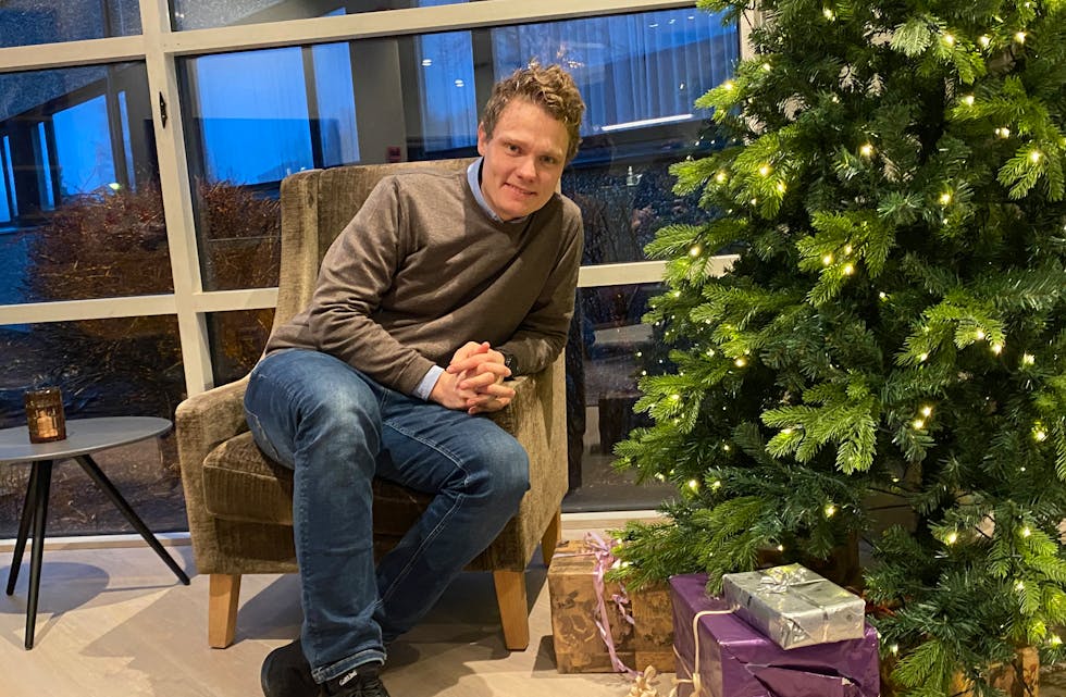 GÅVETRE: Direktør Ottar Langåsdalen ved juletreet i hotell-lobbyen der folk kan legge julegåver til Omvendt julenisse. Pakkene merkar ein med mottakars kjønn og alder.