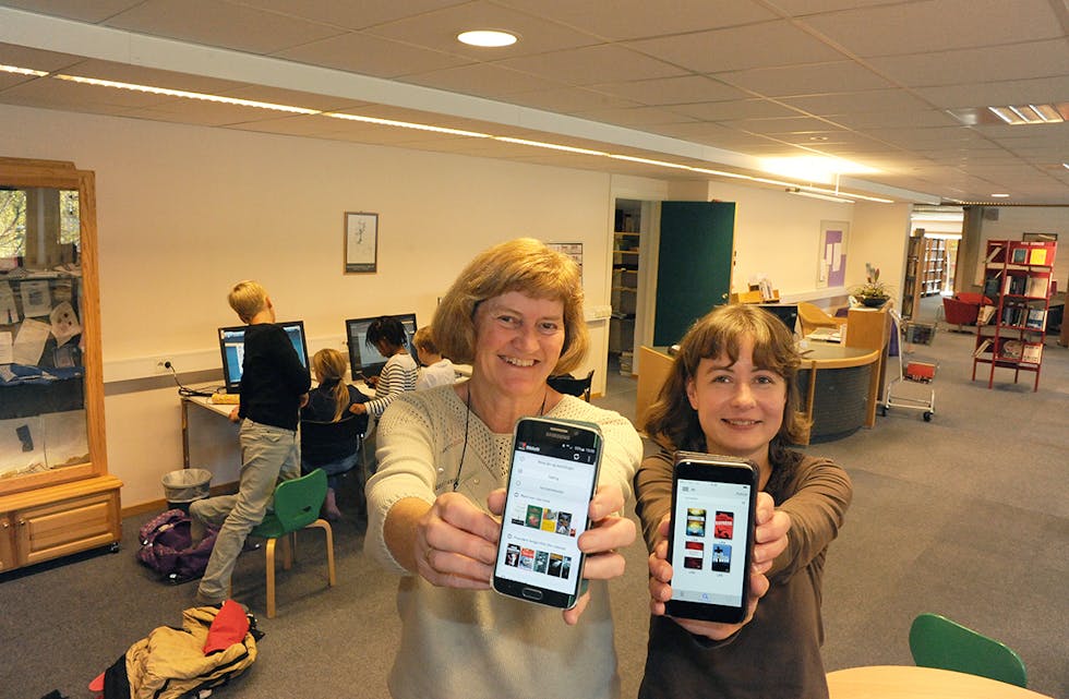Bibliotekar Anne Marie Bråthen (t.v.) og biblioteksjef Ingvild Elvestad Tørre viser bøker som kan lånast gjennom appen eBokBib.