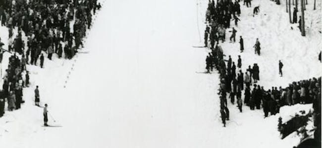 Frå eit renn i Sandvollbakken med betre vêr og fleire tilskodarar enn i februar 1955. Sandvollbakken blei offisielt opna i høve 60-årsjubileet til Skarphedin i 1951 og var i bruk fram til 1958. Det høge hopptårnet blei rive i 1962.