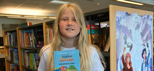 SOMMARLES: Lilli Nymoen Høibø (8) har akkurat fått seg eiga lånekort og er med i årets Sommarles. I videoen fortel ho om favorittbøkene sine. 